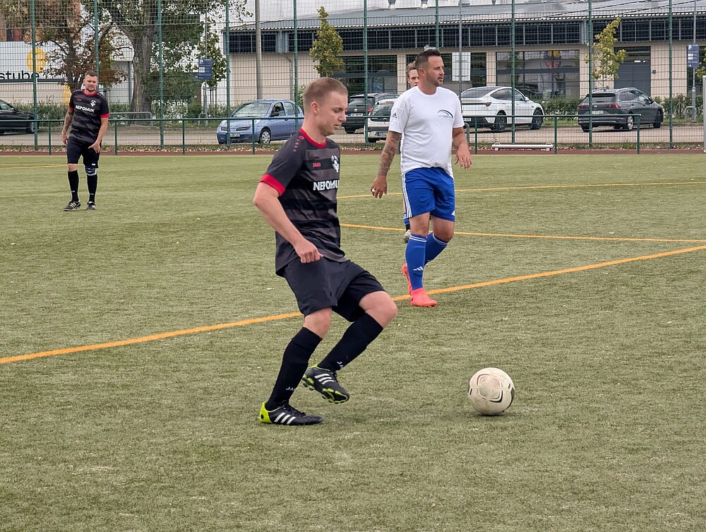 Ein KKH-Fußballer und ein Weimarer Fußballer laufen nach dem Ball