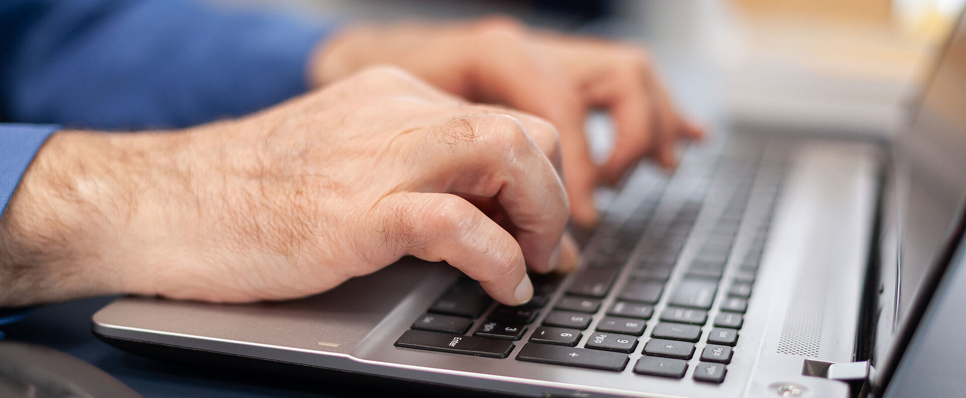 Ältere Hände auf Laptop