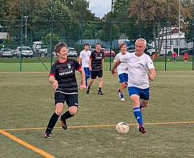 Eine KKH-Fußballerin und ein Weimarer Fußballer laufen nach dem Ball